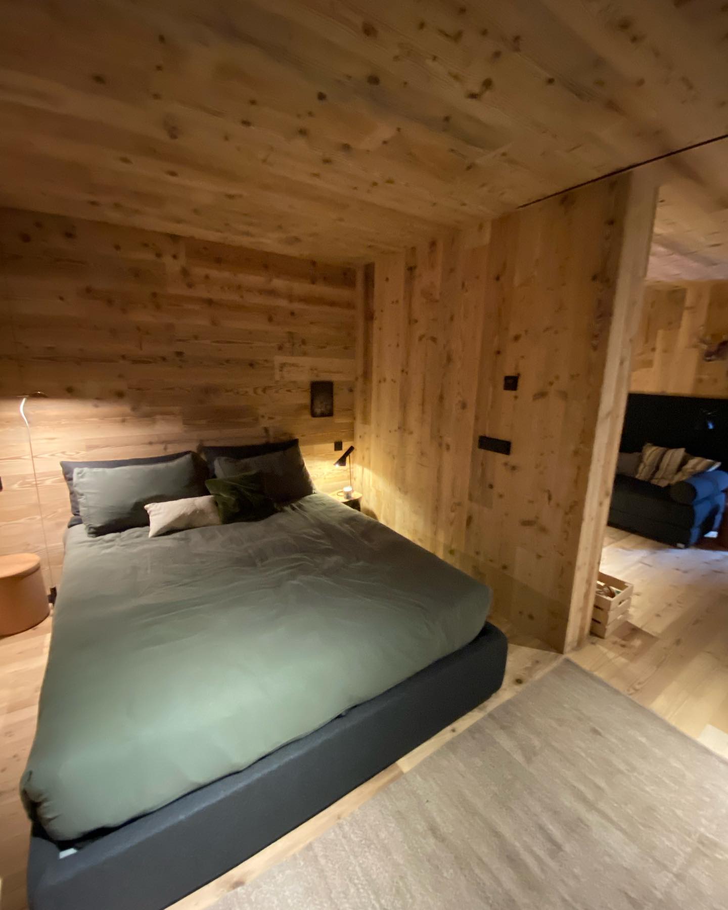 Camera con pareti e soffitto rivestiti in abete di recupero