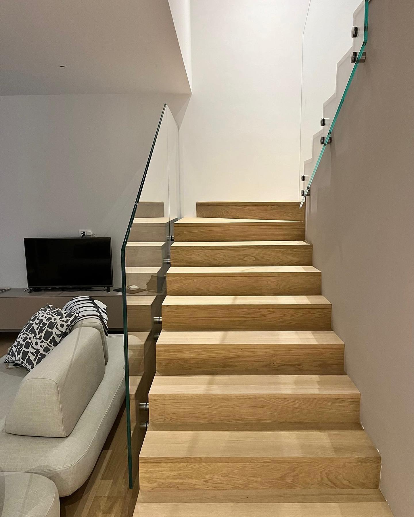 Scala rivestita in rovere rustico verniciato effetto grezzo con parapetto in vetro
